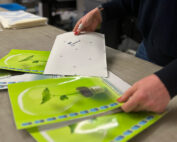 Printer looking through large format materials on workbench.