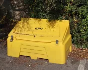 Roadside grit bin sat amongst shrubs